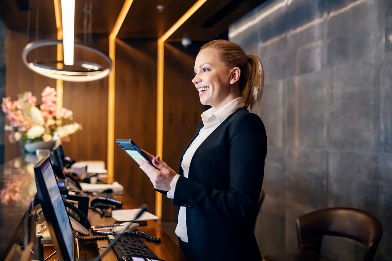 Hospitality team member using a tablet at a reception desk